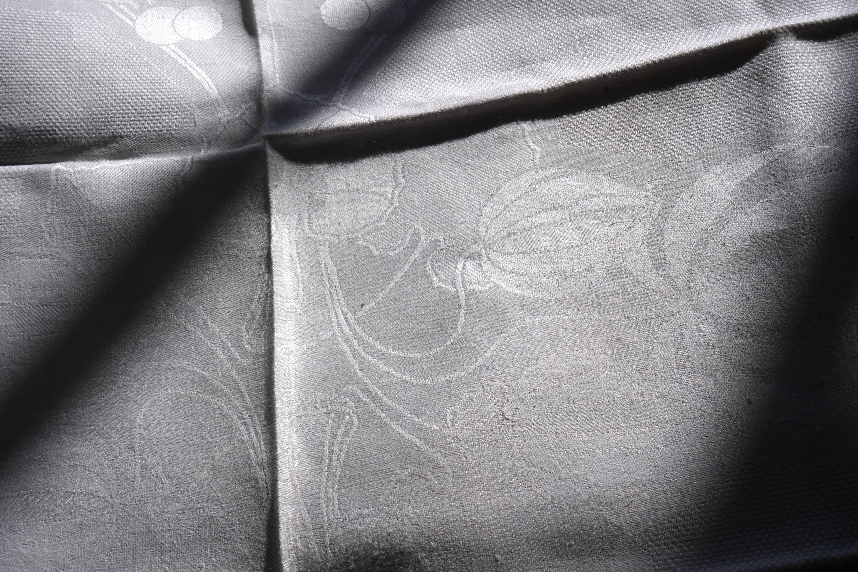 A set of four large Art Nouveau, unused white damask woven hand towels. The pattern having strong Archibald Knox and Walter Crane design elements; with trailing Honesty seeds and Tulip flower heads, these motifs much use